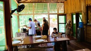 a group of people standing around a table in a kitchen at Paroá Amazon Lodge in Manacapuru