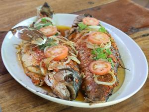 een bord met vis en tomaten op tafel bij Paroá Amazon Lodge in Manacapuru