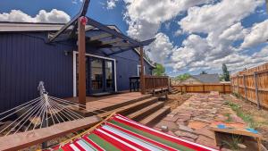 a hammock on a patio next to a blue house at Hot Tub, 3 Bedrooms 2 Baths, Walk to Everything! in Flagstaff