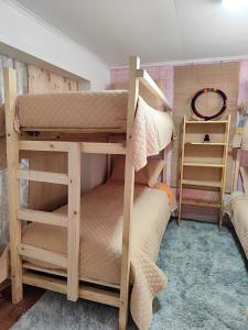 a bunk bed room with two bunk beds and a ladder at La Casa de Sandrita in Castro