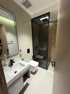 a bathroom with a sink and a toilet and a mirror at فندق نخبة العارض in Riyadh