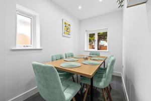 a dining room with a wooden table and green chairs at Coventry Arena Escape in Longford +13 photos