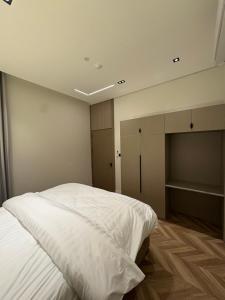 a bedroom with a white bed and a closet at فندق نخبة العارض in Riyadh +5 photos