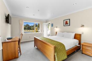 a bedroom with a bed and a window at Ngati Ruanui Mountain Lodge in Stratford