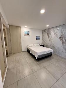 Un dormitorio con una cama y un cuadro en la pared. en Apartaestudio Luiggis Cucuta, en Cúcuta