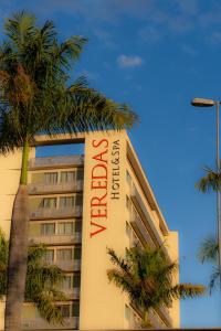 a hotel with a sign on the side of a building at San Diego Suites Veredas Sete Lagoas in Sete Lagoas