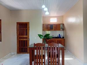a kitchen with a wooden table and two chairs at Casa c wifi, 2 Qts, 3 camas, ganchos p redes e estacionamento in Santarém