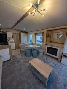 ein großes Wohnzimmer mit Tisch und Couch in der Unterkunft Elegant caravan home in Hampshire, United Kingdom 6 guests 2 bedroom 3 beds 1 sofa bed 2bathrooms in Hayling Island + 5 Fotos