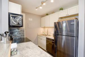 a kitchen with a stainless steel refrigerator and white cabinets at Kauhale Makai 212 in Kihei