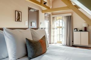 a bedroom with a bed with white pillows and a window at Metzlr House in Haarlem