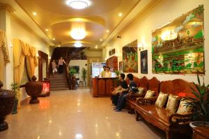 two people sitting on a couch in a store at Lux Guesthouse in Battambang