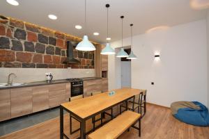 una cucina con tavolo e sedie in legno e lavandino di Wanderlust Guest House Inn Northern Avenue a Yerevan