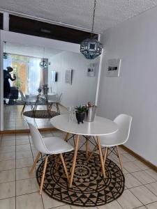 a dining room with a white table and chairs at Cosy flat with garden near Loftus & embassies in Pretoria +23 photos
