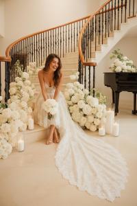 a woman in a wedding dress sitting on the stairs at Fernside house and barns in Pickmere +40 photos