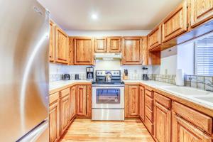 a kitchen with wooden cabinets and a stainless steel refrigerator at Aspenwood Ski Getaway in Ketchum
