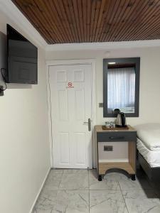 een slaapkamer met een bed en een deur met een televisie bij Sefaa Otel in Sultanahmet