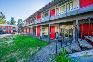 a building with red doors and a grass yard at Hotel O Rama Inn & RV Park in Washougal