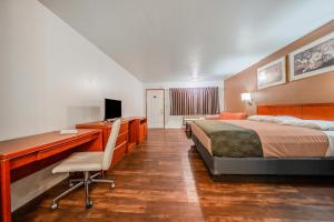 a hotel room with a bed and a desk with a computer at Hotel O Rama Inn & RV Park in Washougal