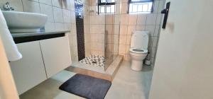 a bathroom with a toilet and a sink at Closer to CBD by UrbanCove in Nelspruit +7 photos