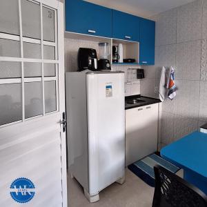 a kitchen with a white refrigerator and blue cabinets at WK Flat em Porto de Galinhas in Porto De Galinhas +8 photos