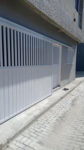 a white gate on the side of a building at WK Flat em Porto de Galinhas in Porto De Galinhas