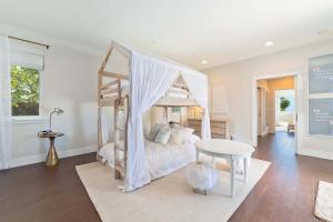 1 dormitorio con cama con dosel y mesa en Luxury Retreat in Kona with Saltwater Pool, en Kailua-Kona