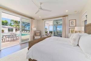 Un dormitorio con una cama blanca y un balcón. en Luxury Retreat in Kona with Saltwater Pool, en Kailua-Kona