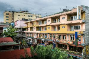 a tall yellow building with balconies in a city at Hotel Nana in Kathmandu