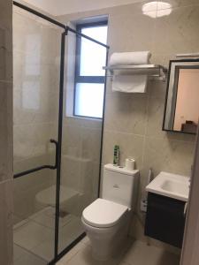 a bathroom with a toilet and a shower and a sink at Imani Homes in Nairobi