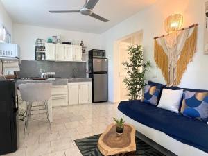 a living room with a blue couch and a kitchen at Charming 1 bdr apt w/ pool 5min Popi beach in Las Terrenas