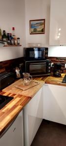 cocina con encimera de madera y microondas en Duplex Sables d'Or, en Fréhel
