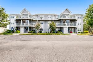 a large white apartment building with a parking lot at Bethany Bay - 8004 Pettinaro Dr in Cedar Shores