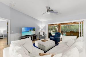 a living room with white furniture and a flat screen tv at Barfield Bay Tuckaway in Rookery Island +35 photos