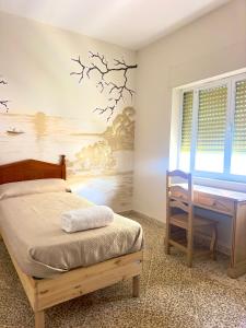 オルヒバにあるHostal Dar Alpujarraのベッドと机のある寝室