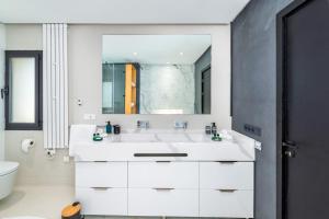 a white bathroom with a sink and a mirror at Villa Anzar Refined Oasis wChef and Emerald Hammam in El Rhechat +5 photos