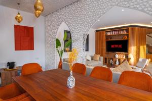 a dining room with a table and chairs and a living room at Villa Anzar Refined Oasis wChef and Emerald Hammam in El Rhechat