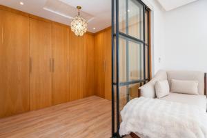 a bedroom with a bed and a glass closet at Villa Anzar Refined Oasis wChef and Emerald Hammam in El Rhechat