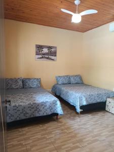 アキダウアナにあるRancho Radicalのベッド2台と天井ファン付きの寝室