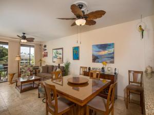 a dining room and living room with a table and chairs at Wailea Grand Champions 111 in Wailea