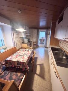 a kitchen with a table in the middle of a room at Casa Checolongo in Ziano di Fiemme