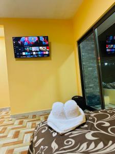 a room with a bed with a tv on the wall at Hospedaje chachalacas in Chachalacas