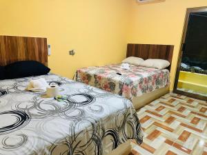 a hotel room with two beds and a window at Hospedaje chachalacas in Chachalacas