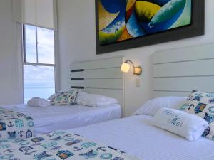 deux lits côte à côte dans une chambre dans l'établissement Hermoso Apartamento de lujo frente al mar, à Coveñas
