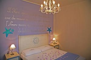 a bedroom with a bed with a writing on the wall at Sogno di Rena in Castelsardo