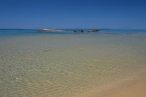 una spiaggia con increspature nella sabbia e nell'oceano di Sogno di Rena a Castelsardo