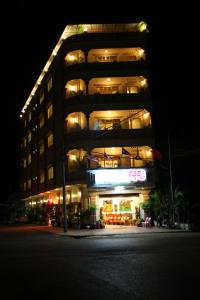 ein hohes Gebäude mit Lichtern in der Nacht in der Unterkunft Lux Guesthouse in Battambang