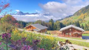 ノートル・ダム・ド・ベルコンブにあるChalets Savoie Les chalets d'Heidiの花が咲く野原にある木造の建物