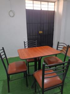 a wooden table and chairs in a room at Hospedaje - A y C in Lima