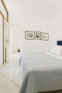 1 dormitorio blanco con 1 cama y 3 cuadros en la pared en CAPRI DESIGN ROOM, en Capri