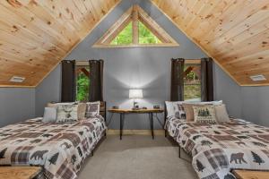 two beds in a attic room with a window at Bear Necessities in Beech Mountain